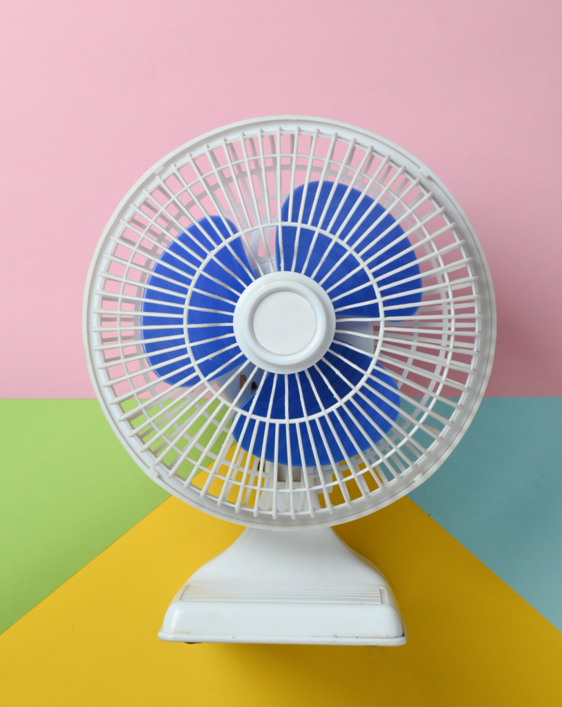 white and blue fan on a multicolored wall background